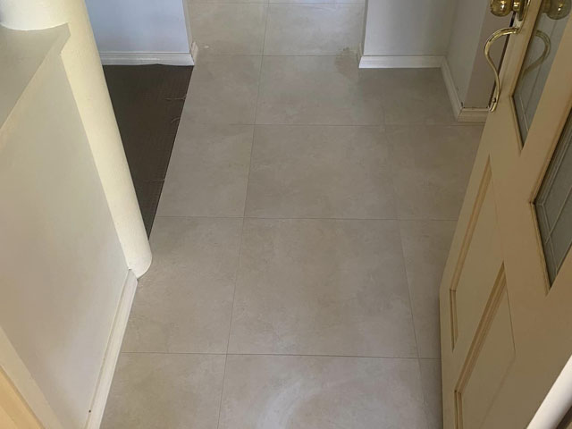 Same hallway after retiling with large pale grey floor tiles