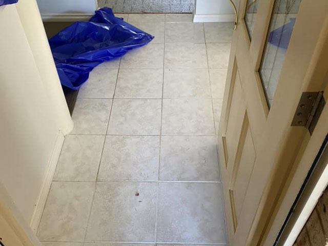 Hallway floor before retiling: old cream ceramic tiles