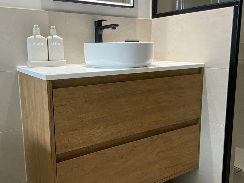 Timber-look vanity with white vessel basin and black mixer tap