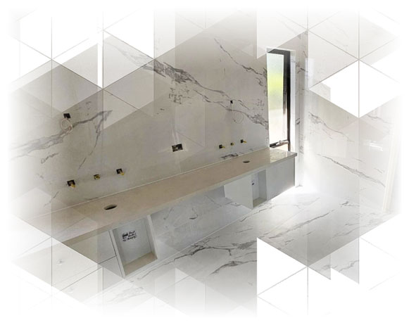 serv1 Marble-look tiled bathroom with a long floating vanity bench and brass taps