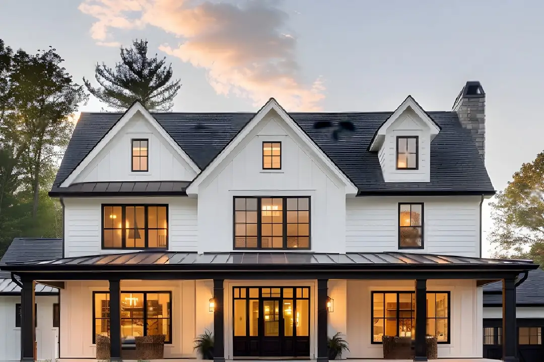 Luxury Home Renovations Perth Two-storey white weatherboard house with black roof and lit windows at dusk