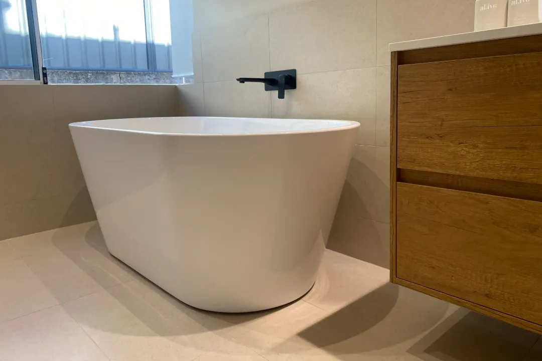 Bathroom Renovations Bayswater Freestanding bath beside a timber-look vanity with a black wall tap