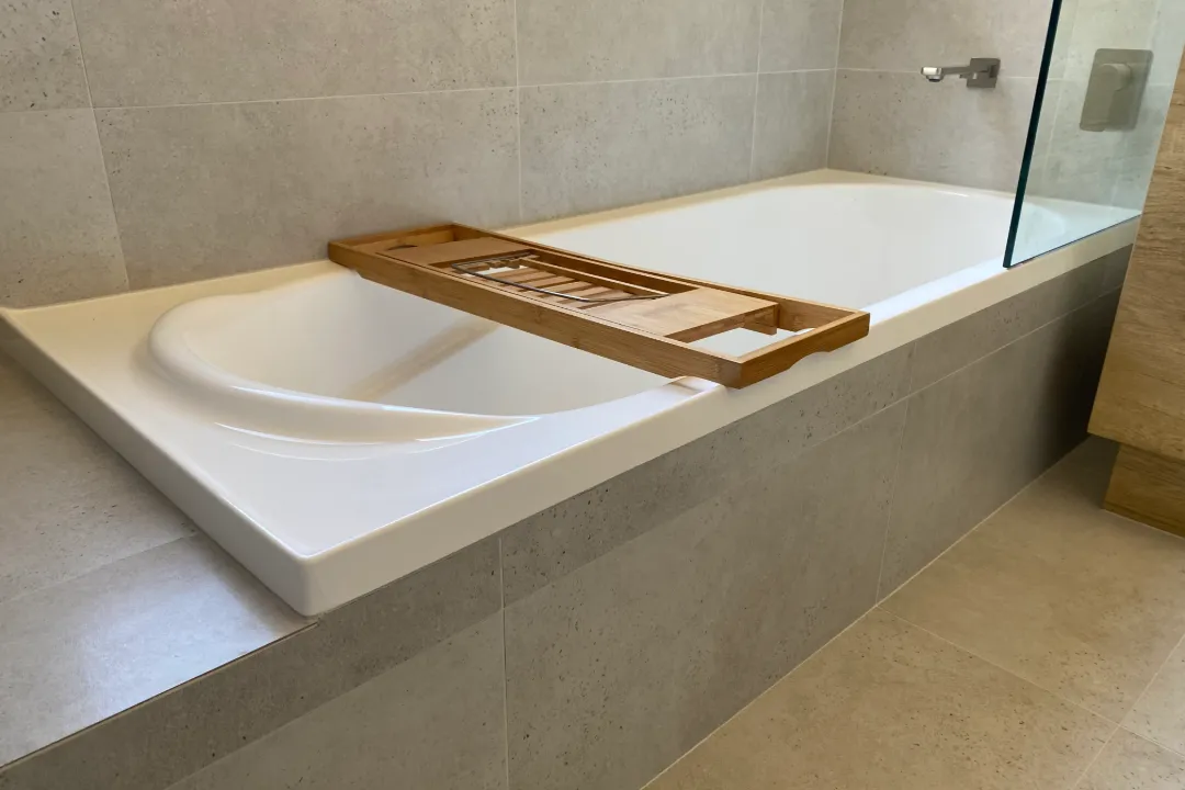 Bathroom Renovations Joondalup Tiled bath surround with timber bath caddy and glass shower screen