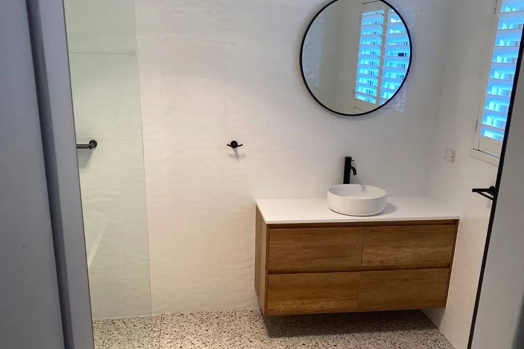 Bathroom Renovations Joondalup Timber-look wall-hung vanity with round basin, round mirror and terrazzo-look floor