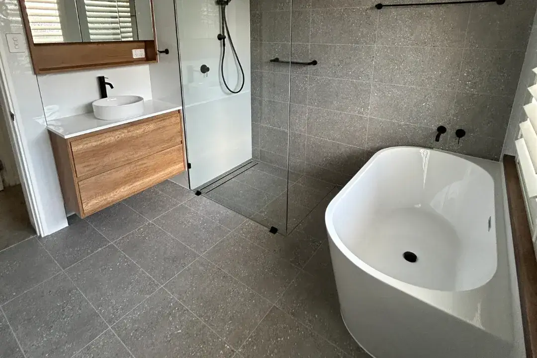 Bathroom Renovations Woodvale Grey-tiled bathroom with freestanding bath, timber-look vanity and walk-in shower