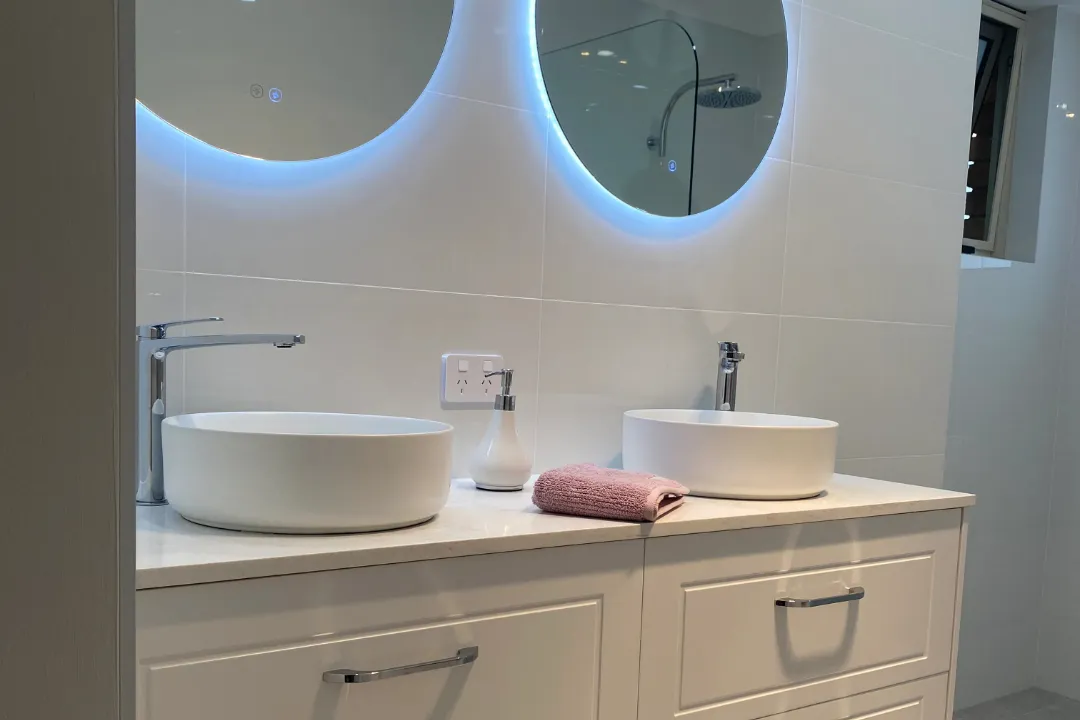 Bathroom Renovations Woodvale White double vanity with two round basins and backlit round mirrors