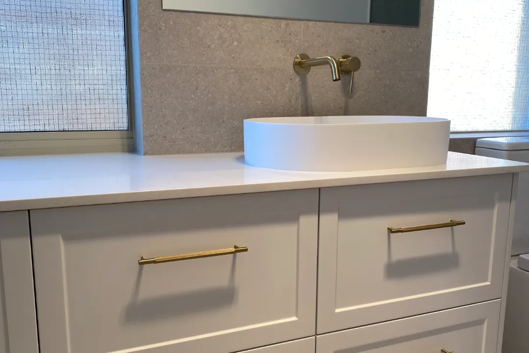 Bathroom Renovations Ellenbrook White shaker-style vanity with brass handles, oval basin and wall tap